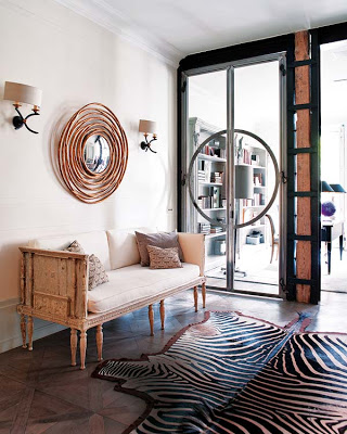 modern entryway in black and white with zebra rug and round mirror via belle vivir blog