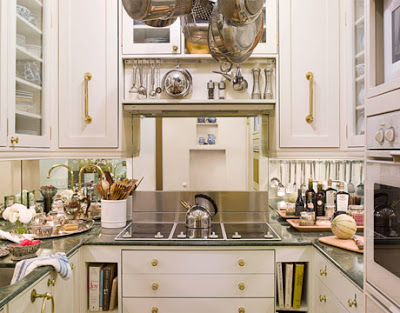 white kitchen with brass handles and mirror backsplash