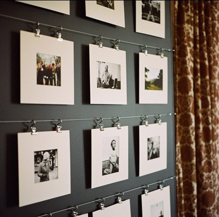 how to create the best gallery walls, a collection of black and white photographs hanging on a metal cord 