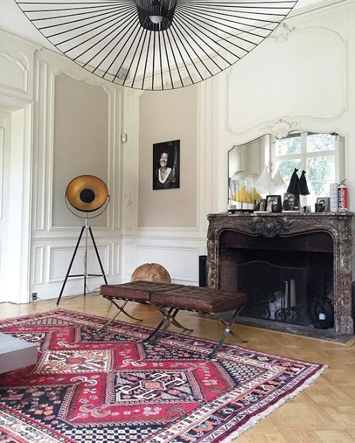 paris living room with parquet floor, marble fire place and vertigo lighting by constance guisset
