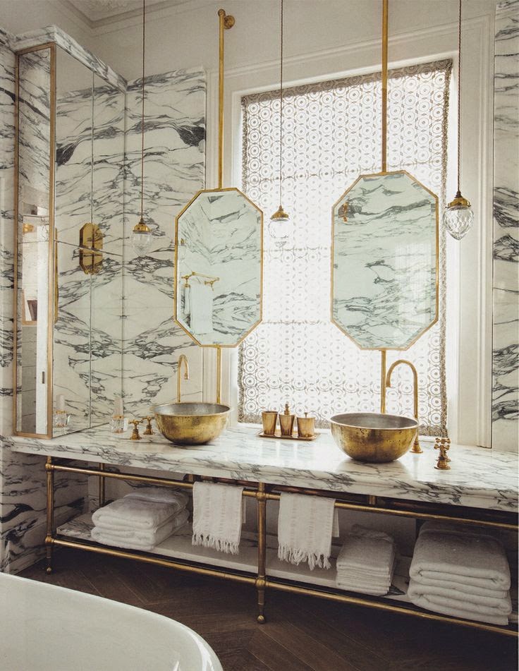 Bathroom with chevron floor, paonazzo marble and brass vanity and floating mirrors in front of windows