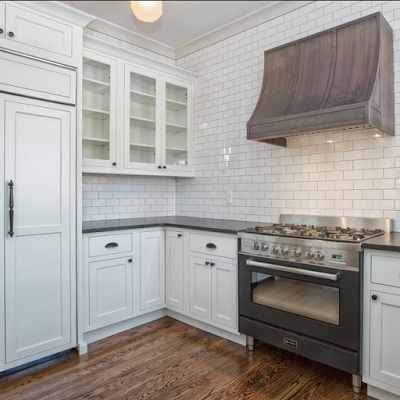 white swbuay tiles, white cabinets, black verona stove and overlay fridge