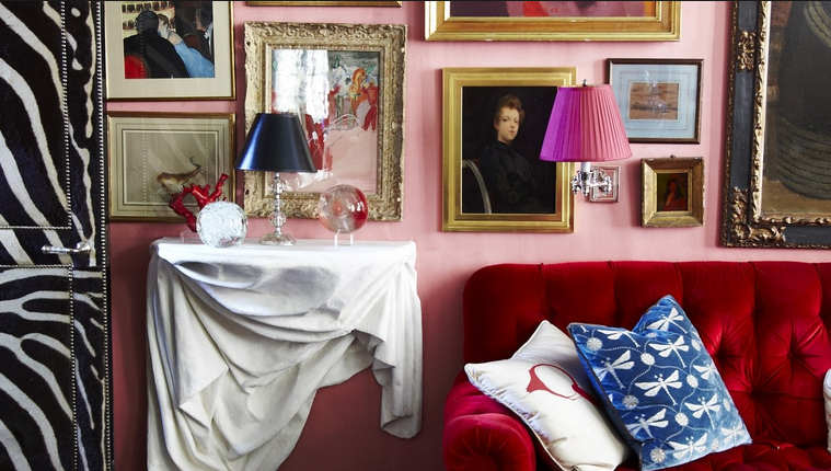 red sofa with portraits on wall