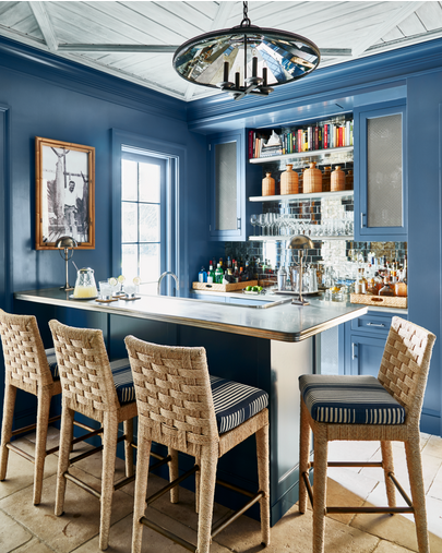 blue walls in a bar, wicker stools in Palm Beach Interior Design